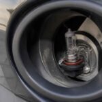 Żarówka halogenowa zamontowana w obudowie reflektora samochodowego