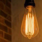 Świecąca żarówka dekoracyjna Edison na tle ceglanej ściany