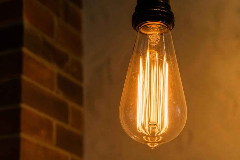 Świecąca żarówka dekoracyjna Edison na tle ceglanej ściany